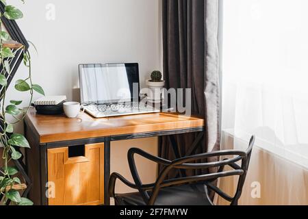 Modern workplace at home with laptop on wooden table Stock Photo
