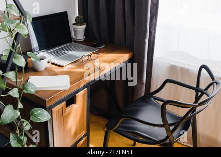 Modern workplace at home with laptop on wooden table Stock Photo