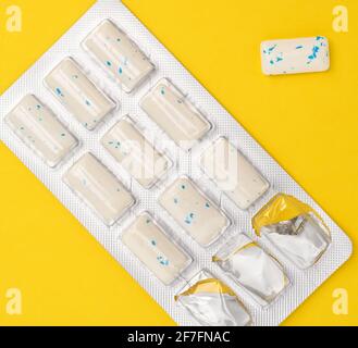 rectangular pieces of gum in a blister pack on a yellow background, top view Stock Photo