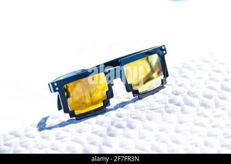 Yellow lenses pixel 8bit sunglasses design shoot in a summer day closeup.Thug life model. Selective focus Stock Photo