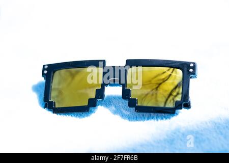 Yellow lenses pixel 8bit sunglasses design shoot in a summer day closeup.Thug life model. Selective focus Stock Photo