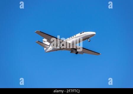 Business jet landing in blue sky Stock Photo