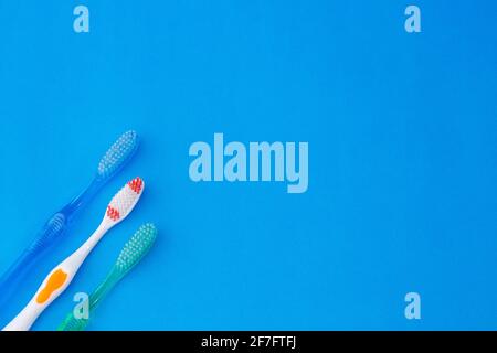 Three tooth brushes on blue background Stock Photo