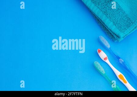 Three toothbrushes - blue towel. Top view Stock Photo