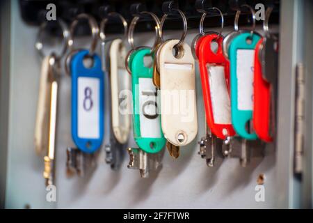 The keys to the doors with tags hang on hooks in a special drawer. Selective focus Stock Photo