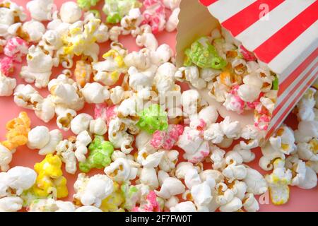 popcorn spilling from a container on red background  Stock Photo