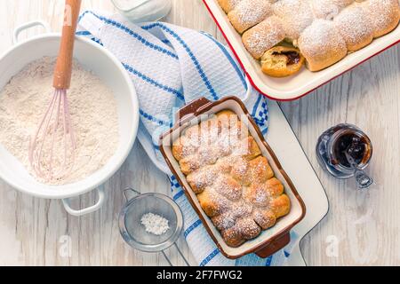 Sweet rolls, Buchteln filled with plum jam or jelly with backing ingredients Stock Photo