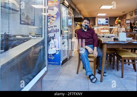 Restaurant in Antalya awaits visitors in early spring during period of coronavirus infection, an employee or owner wears a protective face mask while Stock Photo