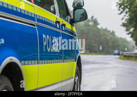 Passenger side of a German police car. View of the lettering Police on the body with the exterior mirror. Blue background and yellow color with reflec Stock Photo