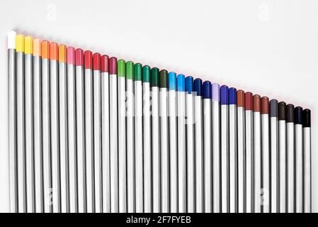 Colored pencils lined up in a row on a pink background, the theme of creativity and hobby. Stock Photo