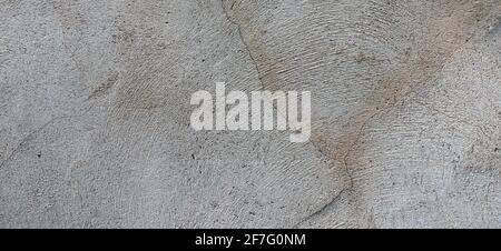 Dark gray concrete plaster wall with dirty cracked scratched texture background Stock Photo