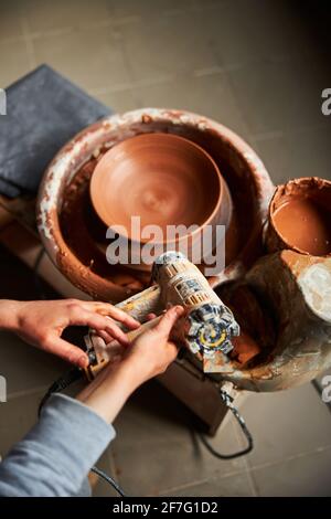 Potter using industrial dryer and making pottery in workshop Stock Photo