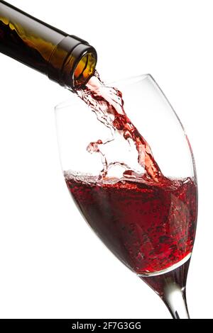 red wine poured from a bottle into a glass isolated on white Stock Photo