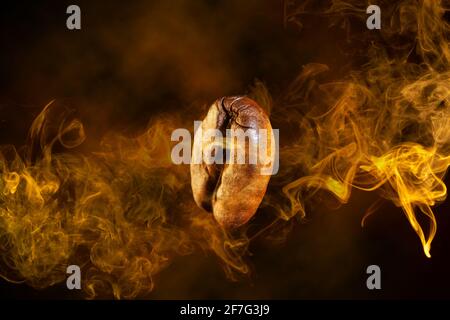 close up of a coffee bean wrapped in orange smoke swirl flying on dark background Stock Photo