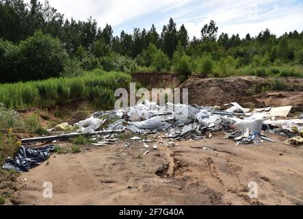 A pile of rubbish in the forest. People throw away food waste and construction waste.Ecological catastrophyfor the environment Stock Photo