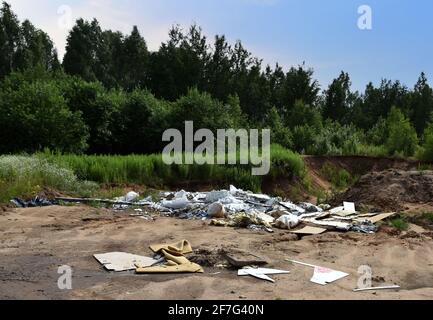 A pile of rubbish in the forest. People throw away food waste and construction waste.Ecological catastrophyfor the environment Stock Photo