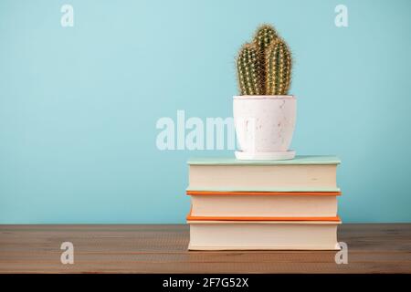 Stack of books and cactus plant on wooden table Stock Photo