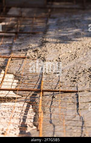 Pouring concrete slabs. Concrete reinforcement and cement casting. Rusty iron and mesh for reinforcement. Stock Photo
