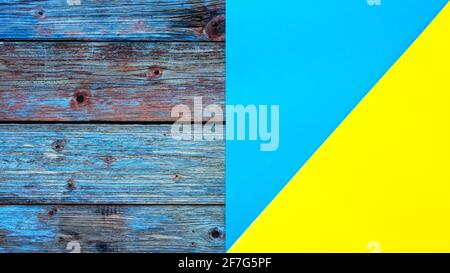 Light blue yellow cardstock on a rustic table constructed from aged wooden planks. Abstract background. Stock Photo