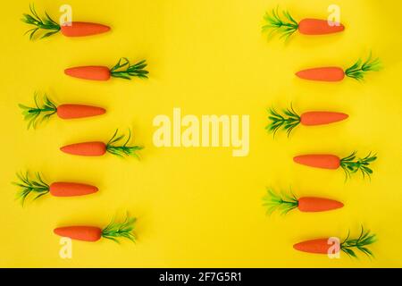 Easter pattern made with carrots on bright yellow background. Minimal Easter composition. Flat lay. Stock Photo