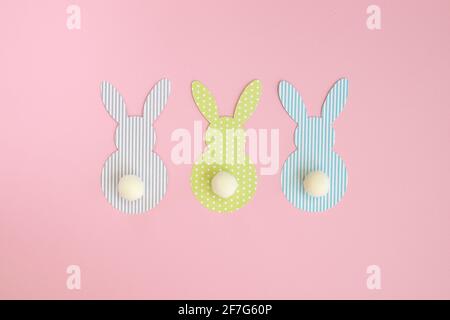 Easter paper bunnies isolated on pink background. DIY holiday handicraft decoration of colorful rabbits. Concept: children's crafts for Easter. Top vi Stock Photo