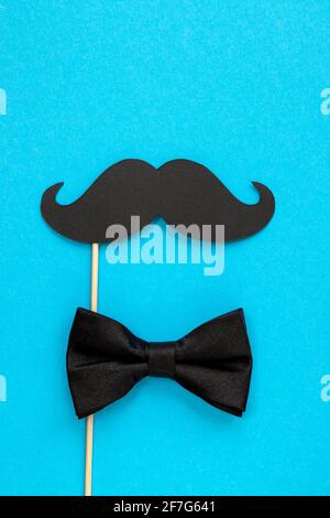 happy father day card, composition with black mustache and bow tie isolated on blue background Stock Photo
