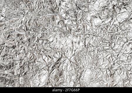 exture of crumpled aluminum kitchen foil, top view closeup, silver foil with shiny surface for background Stock Photo