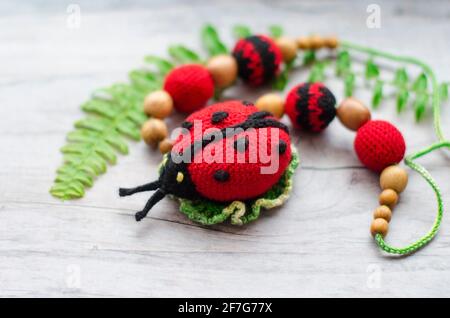 Necklace made from knitted beads and toys for the baby sitting in a sling. Knitted beads. Sling necklace. Stock Photo