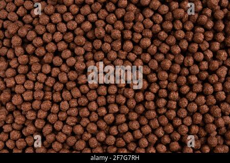 Chocolate breakfast cereal texture. Cereal balls as background. Chocolate corn balls. Top view. Stock Photo