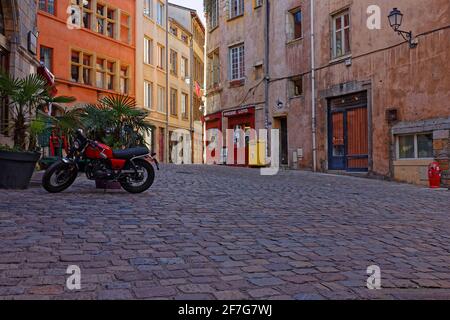 LYON, FRANCE, April 6, 2021 : Place de la Trinité. The square, fully paved and surrounded by old buildings (18th century), is a crossing of small stre Stock Photo