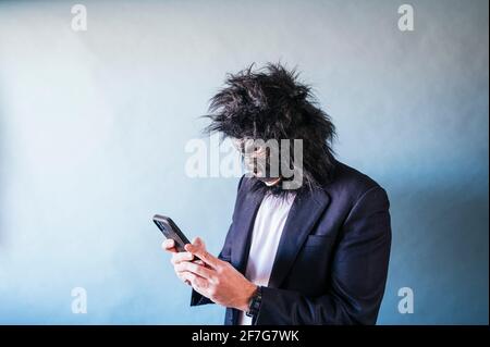 Man with gorilla mask using smart phone Stock Photo