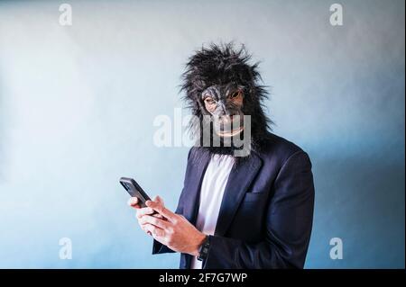 Man with gorilla mask using smart phone Stock Photo