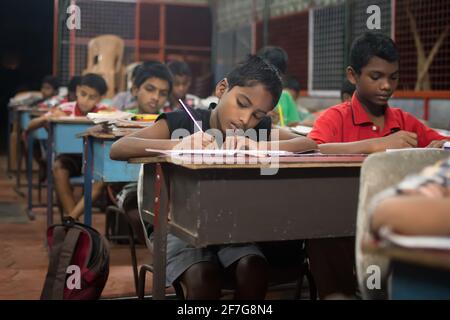 Varanasi, India. 10-16-2019. Children are during their homework at night before having dinner at school. Stock Photo