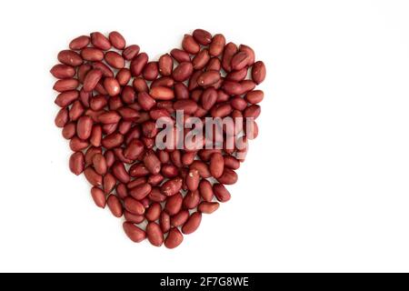 Peanut made in heart shape on white background. Top view. Flat lay. Valentine's day. Symbol of lovers. Stock Photo