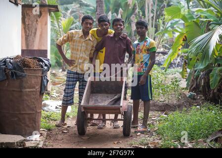 Varanasi, India. 10-16-2019. Group of male teenagers are cleaning the school garden using a shovel and a wheelbarrow Stock Photo