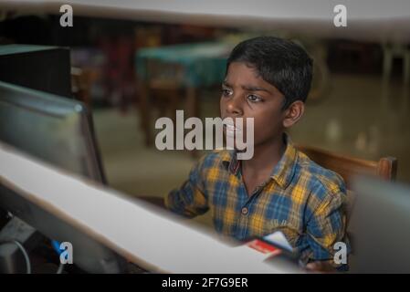 Varanasi, India. 10-16-2019. Portrait of a boy doing his homework with the school computer in Varanasi. Stock Photo