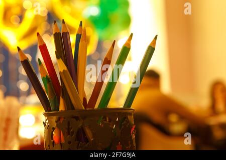 Sharpened colored pencils in a pencil case on a defocused background. Stock Photo