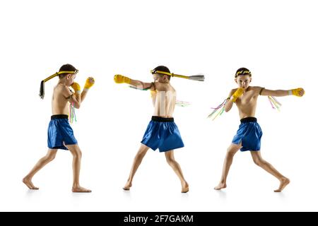 Little boy exercising thai boxing on white background. Fighter practicing, training in martial arts in action, motion. Evolution of movement, catching Stock Photo