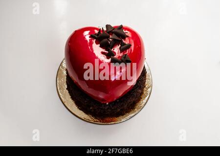 A heart-shaped, cherry-red champagne and berry chocolate miniature cake made for Valentine's Day 2021, Ontario, Canada. Stock Photo