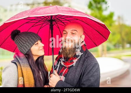 romantic close up portrair of a couple in love of a hipster bald man and caucasian woman wearing winter warm clothes during christmas holidays.pair of Stock Photo