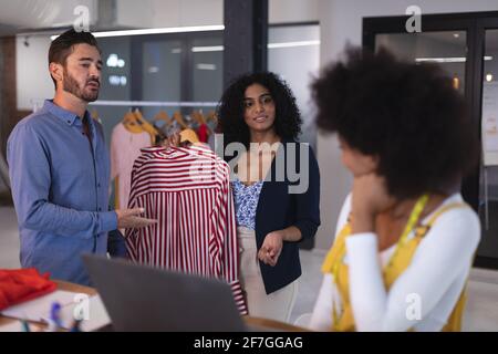 Diverse group of creative fashion designers colleagues in discussion at work Stock Photo