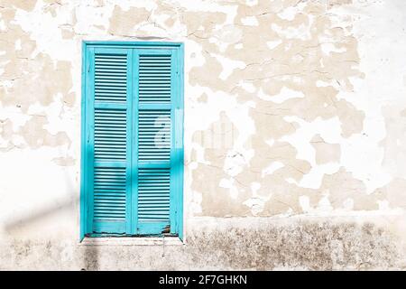 Wooden Turquoise window shutters on a grunge wall Stock Photo