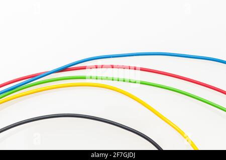 Colored wires, copper wires covered by colored plastic for electrical and technological connections. Cables on white background. Basic colors. Stock Photo