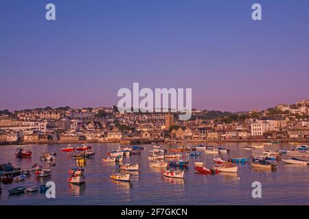 Ives Harbour as the early morning sunlight casts a warm glow over the waterfront in St Ives ,Cornwall ,United Kingdom Stock Photo