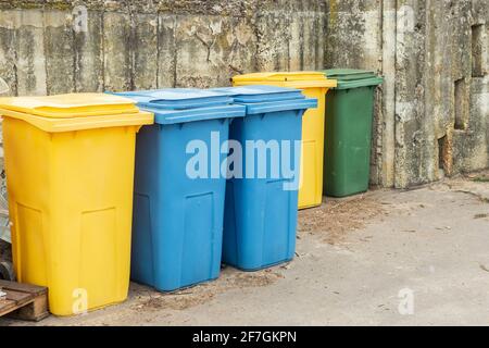 Blue and yellow trash cans or garbage bins outdoors Stock Photo