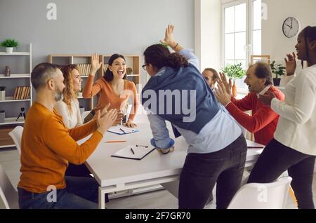 Team of excited diverse people celebrating their business success in office meeting Stock Photo