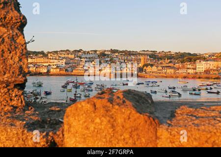 St Ives Harbour as the early morning sunlight casts a warm glow over the waterfront in St Ives ,Cornwall ,United Kingdom Stock Photo