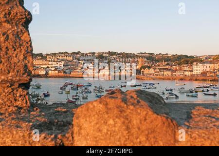 St Ives Harbour as the early morning sunlight casts a warm glow over the waterfront in St Ives ,Cornwall ,United Kingdom Stock Photo