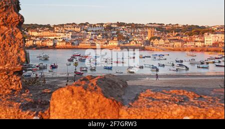 St Ives Harbour as the early morning sunlight casts a warm glow over the waterfront in St Ives ,Cornwall ,United Kingdom Stock Photo