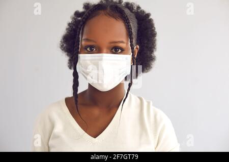 Studio headshot of a young African woman wearing a disposable surgical face mask Stock Photo